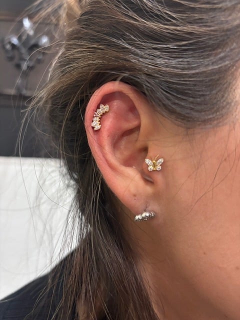 Close-up of womans ear with multiple piercings adorned with diamond and crystal jewelry studs